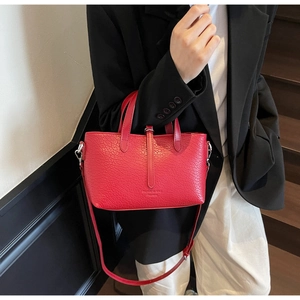 Close-up of red lychee texture leather handbag with Fashion Bag embossed logo
