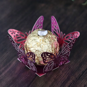 Laser-cut purple butterfly chocolate holder with gold foil truffle on dark wood