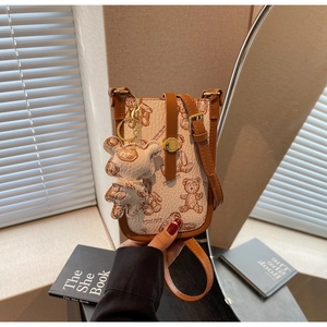 Detailed close-up of a mini crossbody bag featuring a hand-drawn teddy bear and 3D charm