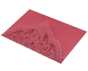 Detailed laser cut lace texture on a dark red paper wedding invitation card