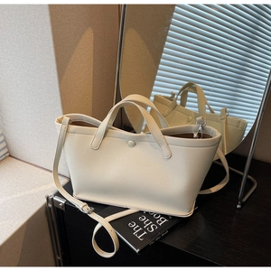 Detailed close-up of cream-white bucket bag with lychee texture on a minimalist surface