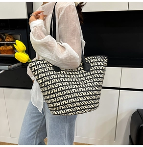Dettaglio di una grande borsa tote intrecciata con spalline in pelle e tulipani