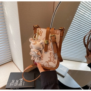 Detail of crossbody phone bag with vintage teddy bear print and cute bear charm