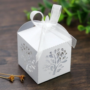 Macro shot of laser-cut tree design on white gift box with elegant ribbon bow