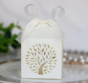 Detailed laser-cut tree design on white pearlescent wedding favor box with ribbon
