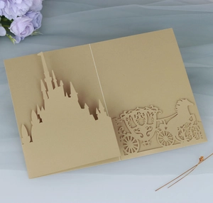 Detailed laser-cut gold wedding invitation featuring a castle and carriage silhouette