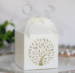 Close-up of laser-cut tree of life candy box with white organza ribbon and pearl finish