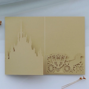Detailed laser-cut gold castle and carriage design on elegant pearl paper invitation