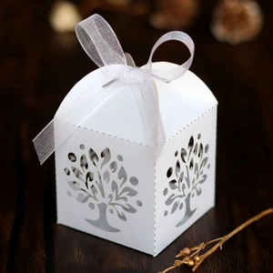 Close-up of white laser-cut hollow tree gift box with elegant white ribbon bow