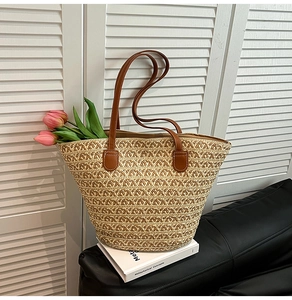 Dettaglio della borsa tote in paglia intrecciata beige con manici in pelle marrone
