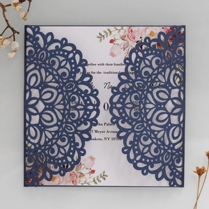 Détail d'invitation de mariage découpée au laser avec papier bleu marine et fleurs