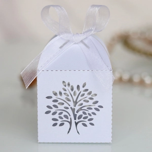 Close-up of a white laser-cut Tree of Life candy box with a delicate organza ribbon bow