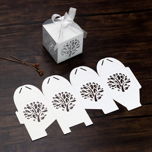 Laser cut Tree of Life white wedding favor box with organza ribbon on wood surface