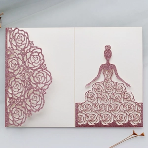 Macro detail of laser-cut glitter girl and rose pattern on pink wedding invitation