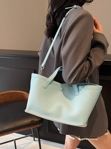Chic light blue lychee pattern leather tote bag shown being worn as a crossbody bucket bag