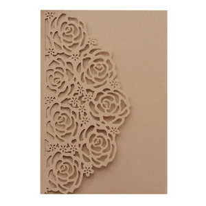 Macro detail of laser-cut rose hollow pattern on brown kraft paper wedding invitation card