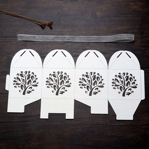 Macro view of laser-cut Tree of Life candy box template with glitter white finish and ribbon