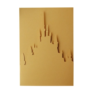 Macro shot of gold laser-cut 3D castle silhouette greeting card with pearlescent finish
