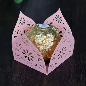 Detail of laser-cut pink paper cupcake liner with intricate floral hollow design