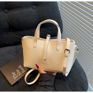Detail of off-white crocodile embossed leather handbag with silver hardware and fashion logo