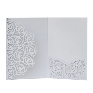 Close-up of elegant laser-cut rose patterns on a white pearlescent wedding card