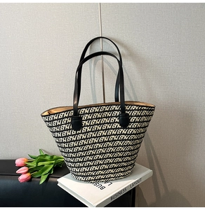 Dettaglio della borsa tote intrecciata bianca e nera con motivo geometrico e manici