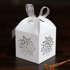 Detailed close-up of white tree laser-cut hollow candy box with organza ribbon bow