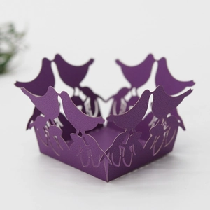 Detail of laser-cut purple paper bird design for wedding cupcake or candy box