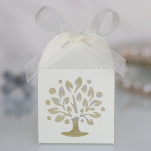 Detail of laser-cut tree of life candy box with elegant white organza ribbon bow