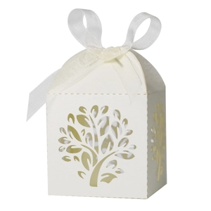 Detail of laser-cut tree of life design on white candy box with white ribbon bow