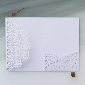 Detailed laser-cut rose hollow design on elegant white pearlescent paper invitation card