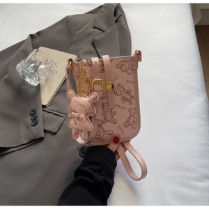 Detailed shot of pink pebble leather mini bag with teddy bear prints and gold buckle closure