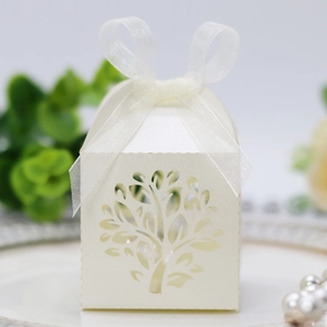 Close-up of laser-cut tree design on white candy box with elegant organza ribbon bow