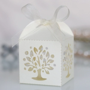 Close-up of white laser-cut hollow tree candy box with an organza ribbon bow tie