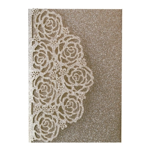 Detail of champagne gold glitter laser cut invitation featuring elegant rose patterns
