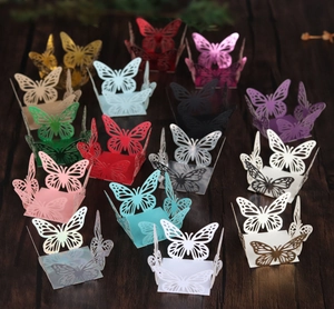 Detail of laser-cut butterfly paper boxes with intricate patterns for party favors