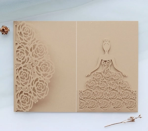 Detail of laser-cut rose border and elegant female silhouette on kraft paper invitation