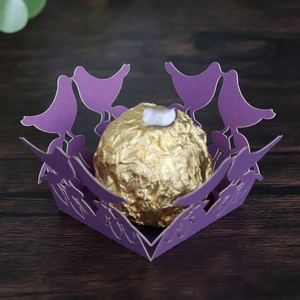 Detail of purple laser cut candy holder with bird motif and chocolate decoration