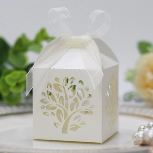 Detail of laser-cut tree design on pearl white candy box with ribbon bow tie