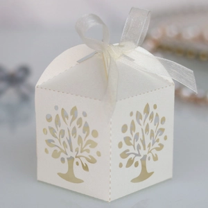 Detail of white laser-cut Tree of Life candy box with elegant white ribbon bow