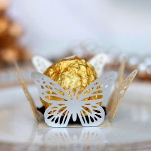 Detail of white laser-cut butterfly chocolate holder with intricate hollow patterns