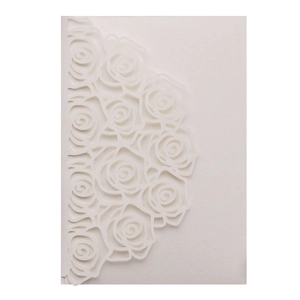 Close-up of laser-cut rose pattern on ivory pearlescent paper wedding invitation card