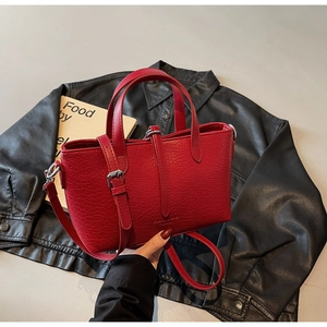 Detail of red crocodile texture handbag with silver hardware and fashion lettering