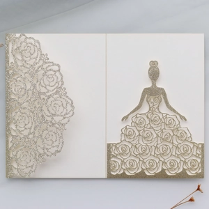 Close-up of laser-cut glitter paper invitation with rose pattern and girl silhouette