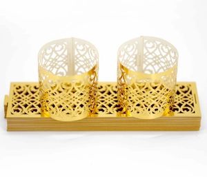 Close-up of golden hollowed butterfly napkin rings with intricate laser-cut patterns