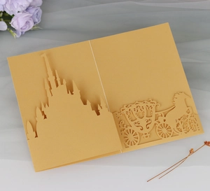 Macro detail of laser-cut golden castle and carriage 3D pop-up wedding invitation card