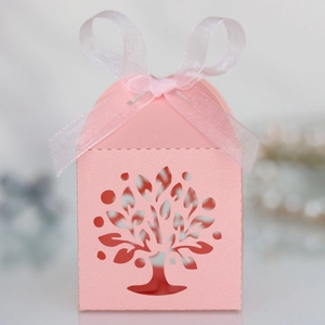 Detail showing pink laser-cut Tree of Life candy box with elegant white ribbon bow