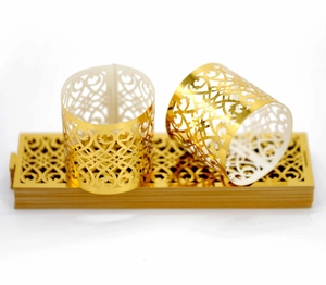 Macro shot of rose gold laser-cut napkin rings with elegant vine hollow patterns