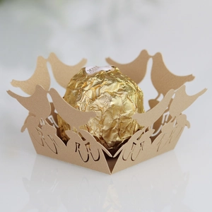 Macro shot of laser-cut hollow lovebird paper candy holder with a chocolate inside