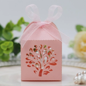 Close-up of pink laser-cut tree gift box with shimmering pearlescent paper and ribbon